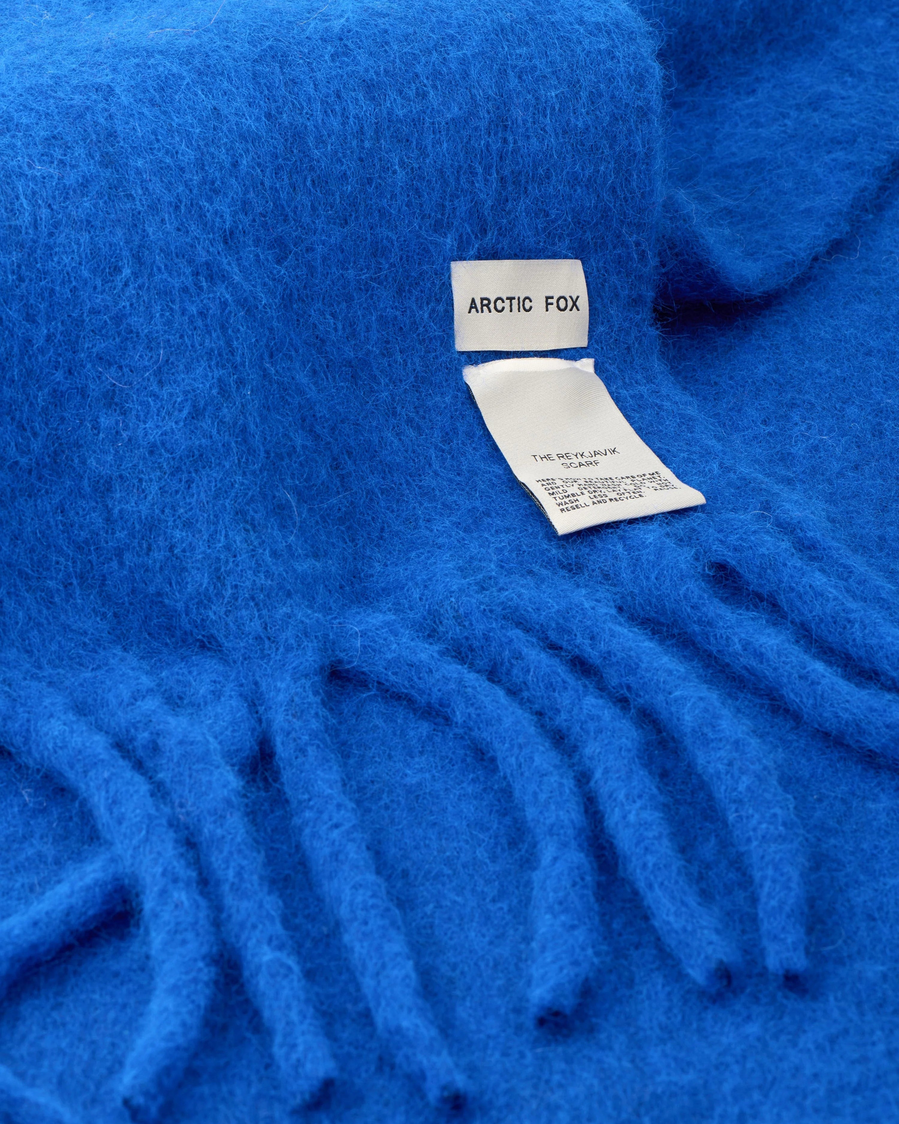 Blue scarf with a visible brand label on a blue background