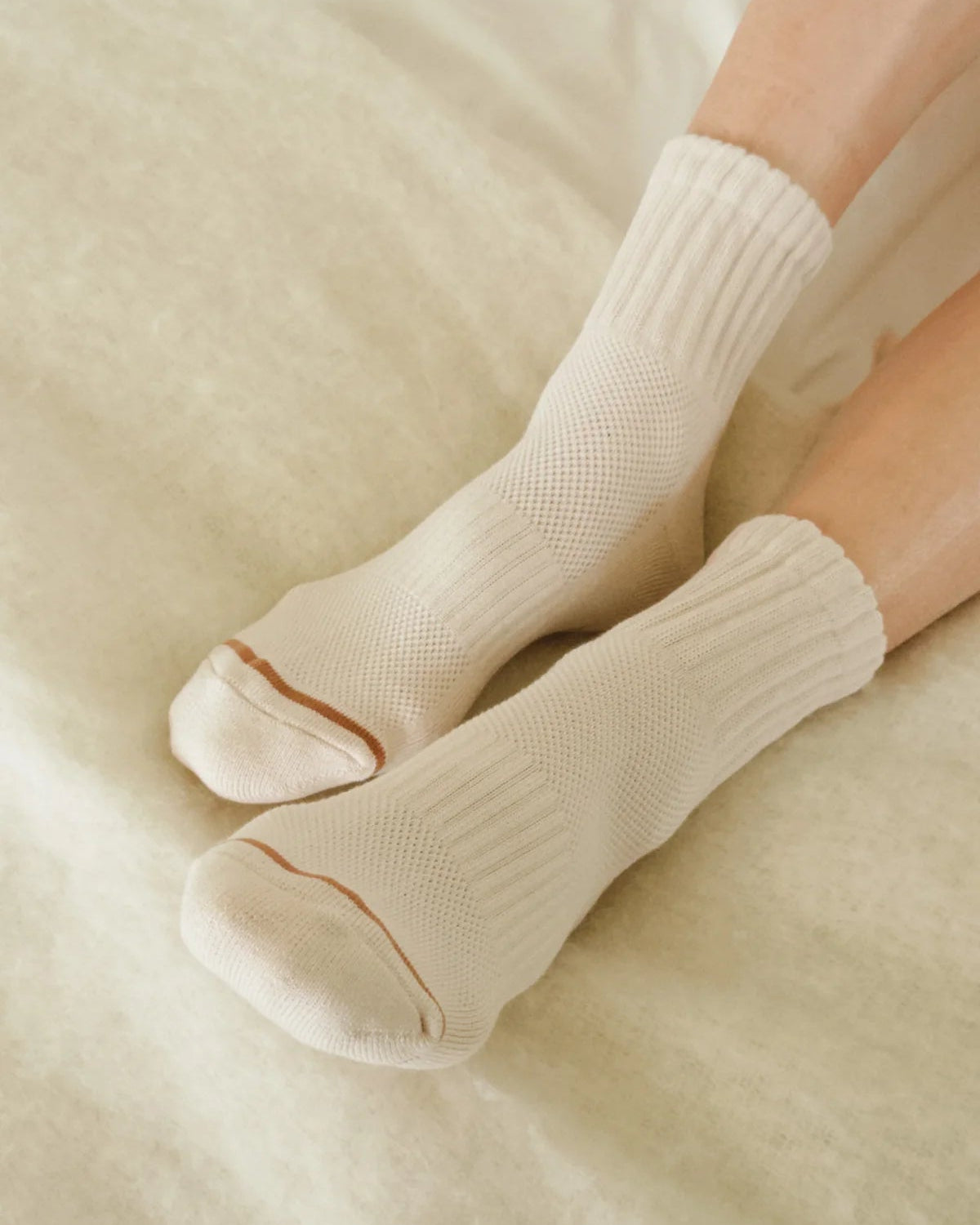 Beige socks worn on a light beige surface